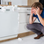 Ein Man stellt schockiert fest, dass seiner Spülmaschine kaputt ist.