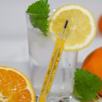 Thermometer in einem Glas Wasser mit Zitrone und Minze