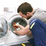 Handwerker repariert Waschmaschine - Kundendienst vor Ort